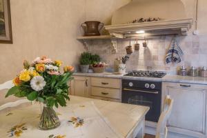 a kitchen with a table with a vase of flowers on it at Tenuta Guardastelle - Agriturismo and vineyard in San Gimignano