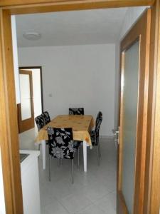 a dining room with a wooden table and chairs at Apartment in Palit with sea view, balcony, Wi-Fi (4606-3) in Mundanije