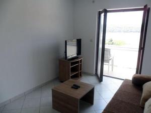 a living room with a couch and a mirror at Apartment in Palit with sea view, balcony, Wi-Fi (4606-3) in Mundanije