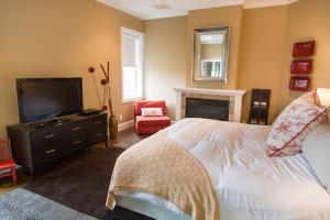 a bedroom with a bed and a television and a chair at Suites at 249 in Culpeper
