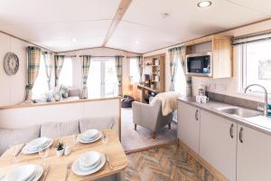 een keuken en een woonkamer in een caravan met een tafel bij Squirrel Lodge with Hot Tub in Pocklington