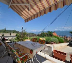 a table and chairs on a patio with a view of the ocean at Apartments Vrbnik (879) in Vrbnik
