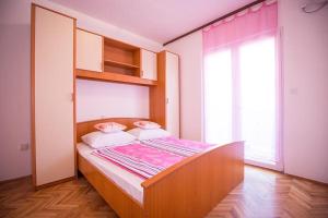 a bed in a room with a large window at Apartments Lopar (4360) in Lopar