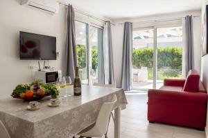 a living room with a table and a red chair at Borgo Aranci - Villa Tulipano in Castellammare del Golfo