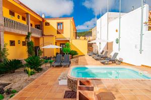 a house with a pool and a blue umbrella at HOTEL EL TEJAR & SPA in Vilaflor