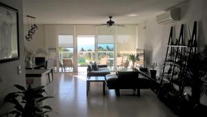 uma sala de estar com um sofá, uma mesa e cadeiras em Swim the Caribbean & Work with a View em Cancún