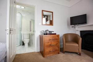 a bathroom with a toilet and a television and a chair at Rewley House University of Oxford in Oxford +11 photos