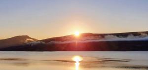 a sunset over a lake with mountains in the background at Rudha-na-Craige in Inveraray