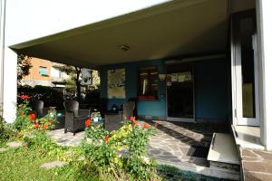 une maison dotée d'une terrasse avec des chaises et des fleurs dans l'établissement Residence Parmigianino, à Parme