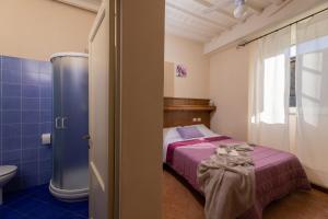 łazienka z łóżkiem i toaletą w pokoju w obiekcie B&B San Francesco w mieście Cortona +25 zdjęć
