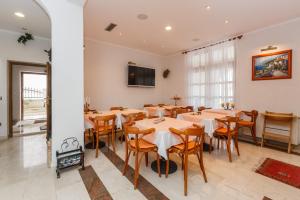 a dining room with tables and chairs and a tv at Room 79-8 in Duće