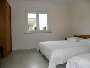 zwei Betten in einem weißen Zimmer mit Fenster in der Unterkunft Apartment in Duce with air conditioning, Wi-Fi, washing machine (4166-1) in Duće