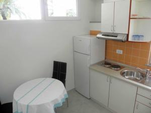 eine kleine Küche mit einer Spüle und einem weißen Kühlschrank in der Unterkunft Apartment in Duce with air conditioning, Wi-Fi, washing machine (4166-1) in Duće