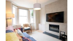 a living room with a couch and a fireplace at Pass the Keys Stunning, Brand New 3BR Home - Central Oxford in Oxford