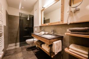 a bathroom with a sink and a toilet and a mirror at Erlenhof Appartements in Grossarl +31 photos