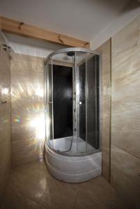 a bathroom with a shower with a glass wall at Drewniany domek Żurawi Trakt in Ząbrsko Dolne