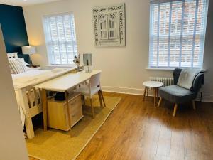 a room with a desk and a chair and windows at The Mews Cottage, with parking, Yarm in Yarm