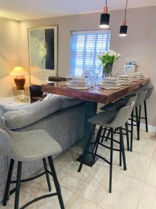 a dining room table with chairs and plates and glasses at The Mews Cottage, with parking, Yarm in Yarm