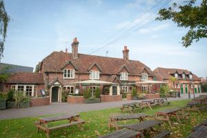 薩徹姆的住宿－Swan, Thatcham by Marston's Inns，一组野餐桌在建筑前