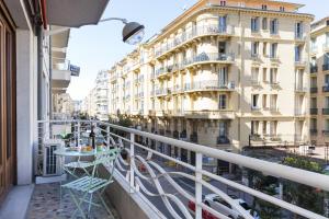 einen Balkon mit Stühlen, einem Tisch und einem Gebäude in der Unterkunft MY CASA - BUFFA 21 in Nizza