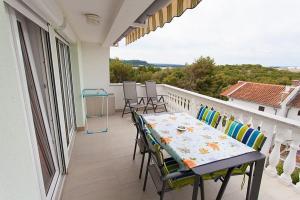 eine Veranda mit einem Tisch und Stühlen auf dem Balkon in der Unterkunft Seaview Apartment Omisalj 3623-2 in Omišalj