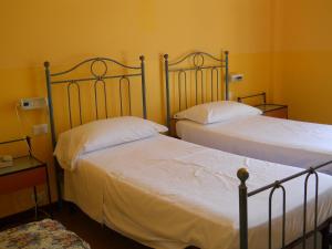 Albergo Ristorante Aquila في سولتسانو: سريرين في غرفة بجدران صفراء