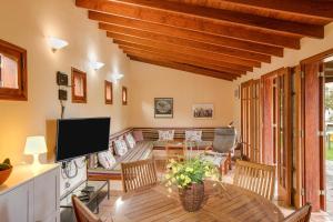 a living room with a wooden table and a television at Casa Elvira Hermigua in Hermigua