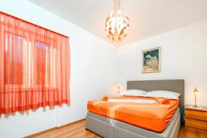 een slaapkamer met een bed en een rood gordijn bij Beachfront Apartments Pisak 102 in Pisak