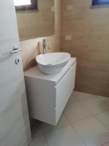 a bathroom with a white sink and a mirror at La Finestra sulla Torre in Stintino