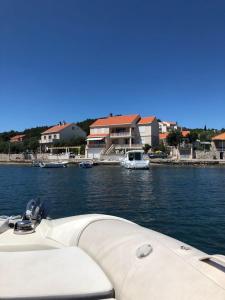 a boat in a body of water with houses at Ferienhaus SIKLUH-128-4 in Lumbarda +33 photos