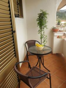a small table and chairs on a balcony with a plant at Room in Palit with balcony, Wi-Fi (4603-3) in Mundanije