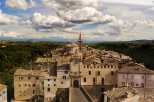 un village avec une tour d'horloge au-dessus d'un bâtiment dans l'établissement La casetta nel granaio, à Capranica