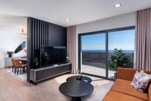 sala de estar con sofá y TV en Villa Belmonte by LovelyStay, en Ponta do Sol