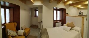 a bedroom with a white bed and two chairs at Apartamentos Turísticos El Peñón in Tapia de Casariego +7 photos
