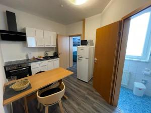 a small kitchen with a wooden table and a counter at Ferienwohnung Altstadt Güstrow in Güstrow
