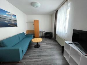 a living room with a blue couch and a tv at Ferienwohnung Altstadt Güstrow in Güstrow