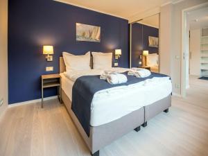 een slaapkamer met een groot bed met een blauwe muur bij Dünenresidenz Prora - Ferienwohnung mit Meerblick, 2 Schlafzimmern und Loggia NP-318 in Binz