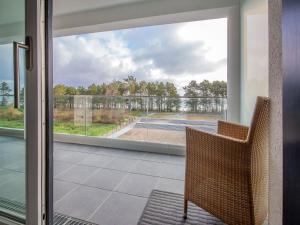 een kamer met een glazen schuifdeur en uitzicht op een tennisbaan bij Dünenresidenz Prora - Ferienwohnung mit Meerblick, 2 Schlafzimmern und Loggia NP-318 in Binz