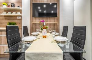 ein Esszimmer mit einem Tisch und Weingläsern in der Unterkunft MF SilverLake Wellness Apartment in Siófok