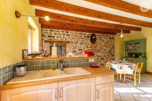 a kitchen with a sink and a stone wall at Gîte de Franc Saône et Loire référencé 1961 Les Perrières entre Autun et Le Creusot chez Maymard Yannick in Antully