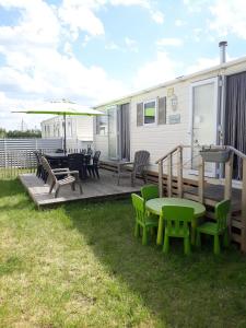 a deck with a table and chairs and an rv at Luxe vakantiechalet met omheinde tuin Bredene 6pers (2572) in Bredene