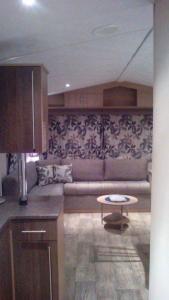 a living room with a couch and a table at Luxe vakantiechalet met omheinde tuin Bredene 6pers (2572) in Bredene