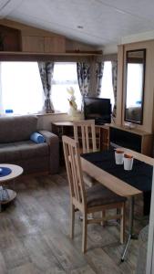 a living room with a table and a couch at Luxe vakantiechalet met omheinde tuin Bredene 6pers (2572) in Bredene