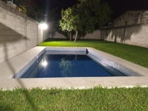 ein Schwimmbad mitten im Garten nachts in der Unterkunft Aquetzali Kin Casa Privada con alberca in Cuautla Morelos