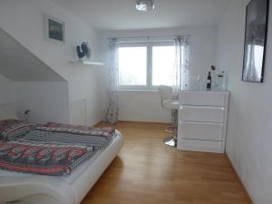 a bedroom with a bed and a desk and a window at Ferienwohnung Pickenhan in Scheidegg