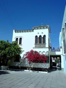 un edificio blanco con balcón y flores rosas en HOTEL CASA CONSTANZA, en San Luis Potosí