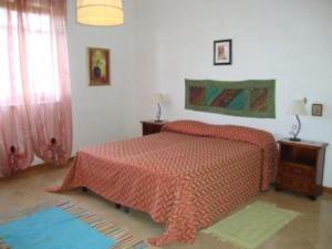 カステッランマーレ・デル・ゴルフォにあるCasa con giardinoのベッドルーム1室(赤い掛け布団付きのベッド1台付)