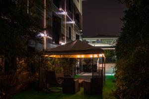 een patio met een parasol voor een gebouw 's nachts bij 57 Reshotel Orio in Orio al Serio