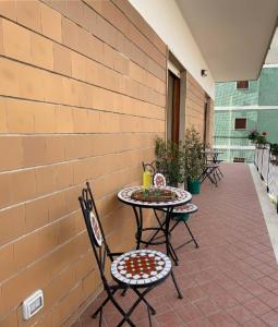 eine Terrasse mit zwei Tischen und Stühlen an einer Ziegelwand in der Unterkunft A Casa e' Mammà in Sorrent