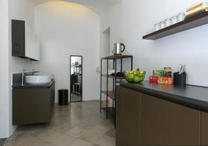 eine Küche mit einer schwarzen Theke und einem Waschbecken in der Unterkunft ATIK ROOMS in Ljubljana